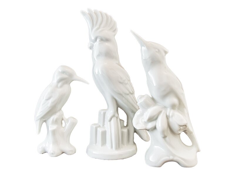 Drei weiße Porzellanfiguren (Vögel) vor weißem Hintergrund